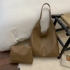 Detail of large brown pebble leather tote bag with a matching small zippered pouch