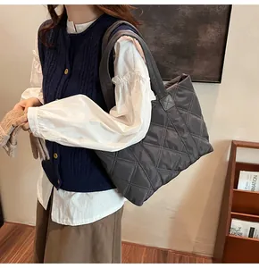 Grand sac cabas matelassé gris foncé avec surpiqûres en losanges porté à l'épaule