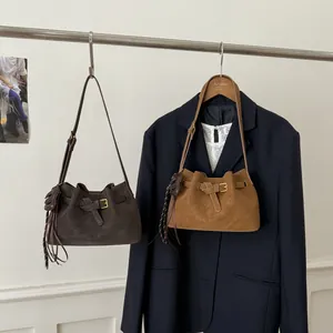 Sac seau vintage en daim avec boucle décorative et longs pompons en gris et caramel