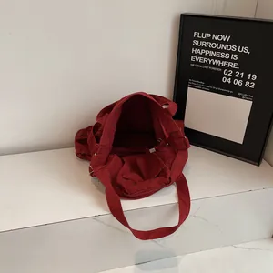 Deep burgundy canvas tote bag with large capacity for work or study in a minimalist setting