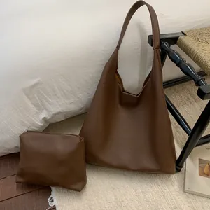 Detail of dark brown lychee leather tote bag with a matching small zipper pouch