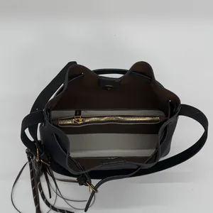 Vue intérieure du sac seau en daim avec design bicolore et compartiment zippé doré