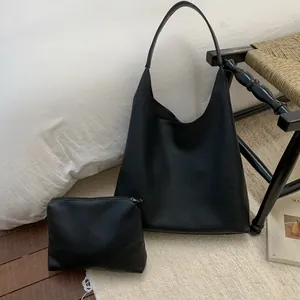 Detail of black large hobo tote bag with matching zipper pouch in pebble leather finish