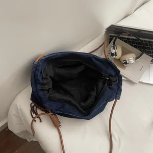 Deep blue denim tote bag with brown rope strap shown from a top view with lifestyle props