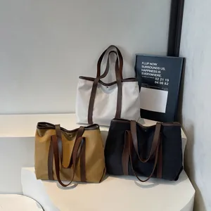 Three minimalist canvas tote bags in white, grey, and brown with leather straps