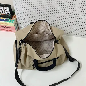 Large beige nylon travel bag with branded lining and detachable crossbody strap
