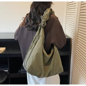 Close-up of olive green tote bag featuring unique pleated ruffled shoulder strap detail