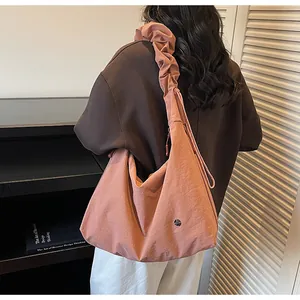 Detail view of pink large tote bag with pleated shoulder strap on model