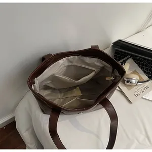 Interior view of large brown tote bag showing zipper pocket and spacious lining