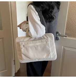 Détail du sac à main d'ordinateur en velours côtelé crème avec poche zippée et style épuré