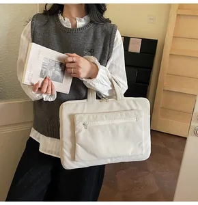 Détail de la texture en velours côtelé et poche zippée sur le sac d'ordinateur blanc
