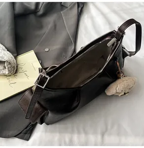 Detailed top view of retro dark brown pillow bag with interior space and plush bear charm