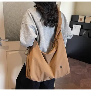 Brown oversized pleated tote bag shown from side view on model for daily commuting