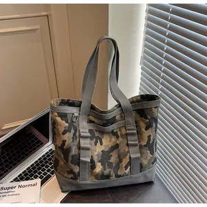 Detail of durable canvas tote bag with camo print, reinforced base and grey handles