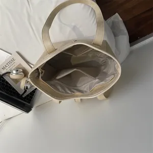Minimalist beige tote bag featuring a spacious interior with pockets and magnetic closure