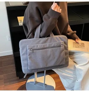 Détail d'un sac cabas pour ordinateur en velours côtelé gris foncé avec des anses larges