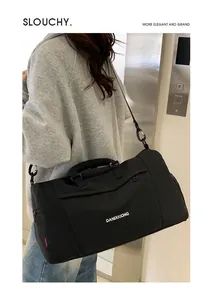 Détail du sac de voyage en tissu Oxford noir avec bandoulière et poche zippée avant