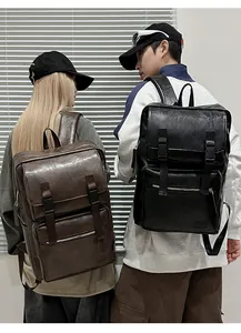 Deux modèles portant des sacs à dos en similicuir noir et marron avec rabat et boucles
