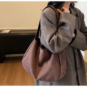 Detalle de un bolso tote grande de ante gris púrpura usado por modelo para ir al trabajo