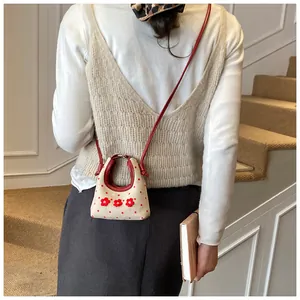 Detail van mini canvas tas met rode stippen en handgemaakte 3D bloemdecoraties