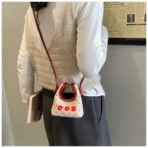 Detailopname van mini canvas tas met rode stippen en gehaakte bloemdecoraties