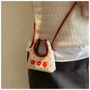 Detail van mini canvas tas met rode stippen en handgemaakte 3D bloemendecoraties
