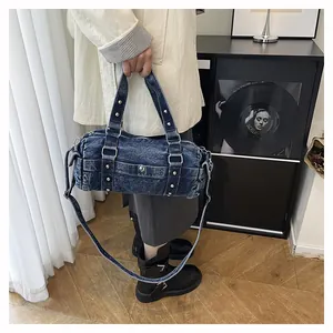 Dettaglio borsa a cilindro in denim lavato con borchie argentate e fibbia regolabile