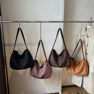 Bolsos tote grandes y minimalistas de ante en varios colores en un soporte