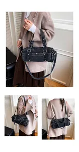 Dettaglio della borsa Boston in denim lavato con borchie metalliche e doppi manici