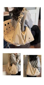 Detail of minimalist beige pleated shoulder strap and logo on a large tote bag