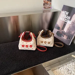 Mini canvas crossbodytassen met stippen, bloemen en rood-bruine lederen handvaten