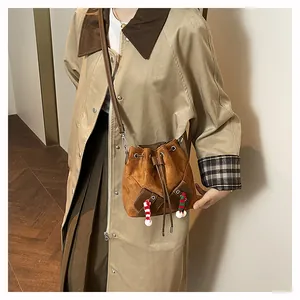 Détails du sac seau marron à cordon avec breloques festives en peluche et bandoulière