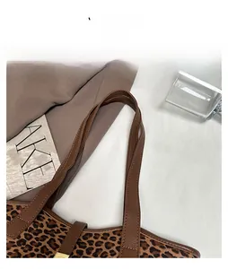 Detailaufnahme des braunen Leder-Schultergurts an der Tragetasche mit Leopardenmuster