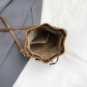 Vue intérieure du sac seau marron à cordon avec doublure rayée et poche zippée