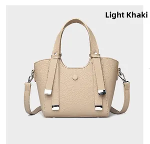 Détail du sac bandoulière kaki clair en cuir grainé avec boucles argentées élégantes