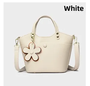 Detail of white lychee pattern leather bucket bag with flower charm and detachable strap