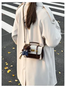 Close-up of retro color-block backpack on model with a cute plush bear charm detail