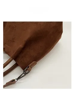 Vue détaillée du sac cabas en daim marron foncé avec finition mate et boucles en métal