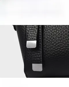 Vue détaillée du cuir grainé noir avec des boucles décoratives en métal argenté mat