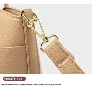 Detail of durable gold metal hook and precise stitching on khaki leather bucket bag