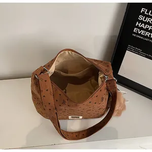Détails de l'intérieur du sac cabas en velours marron avec imprimés et charm en peluche