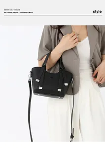 Détail du sac à main en cuir grainé noir avec finitions argentées et pieds de protection