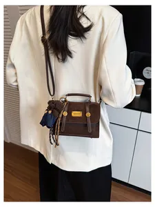 Close-up of retro brown patchwork backpack with gold metal plaque and cute bear charm