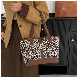 Detail einer Leopard-Tote-Bag mit braunem Lederbesatz und goldener Metallschnalle