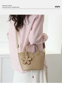Close-up of apricot bucket bag with lychee grain leather and flower pendant detail
