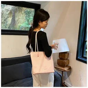 Close-up of pink and white striped tote bag with brand logo tag in home setting
