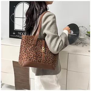 Detail der Leopard-Tragetasche mit braunem Lederbesatz und goldenem Metallverschluss