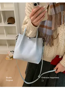 Détail du sac seau en daim bleu clair montrant sa texture douce et sa polyvalence