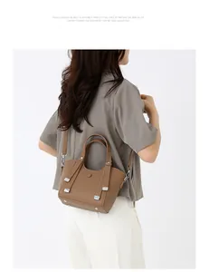 Détails du sac en cuir marron grainé avec rivets de protection et bandoulière réglable