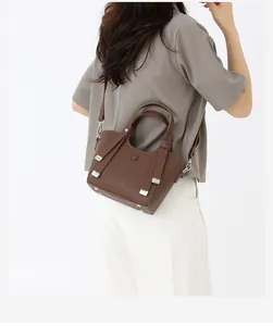 Détail du sac à main marron foncé en cuir grainé avec boucles métalliques argentées